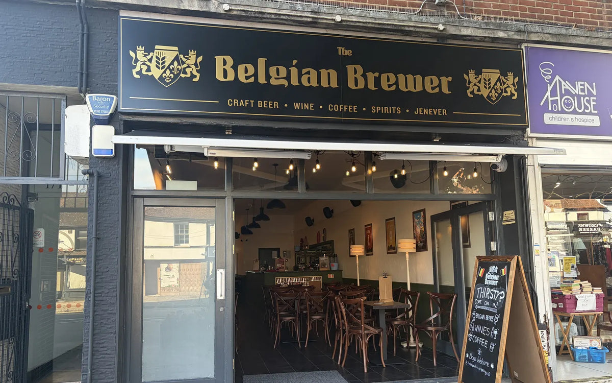 The café on Epping High Street by day: a black and gold The Belgian Brewer sign reading craft beer, wine, coffee, spirits and jenever, folding doors open and a Thirsty? chalkboard on the pavement